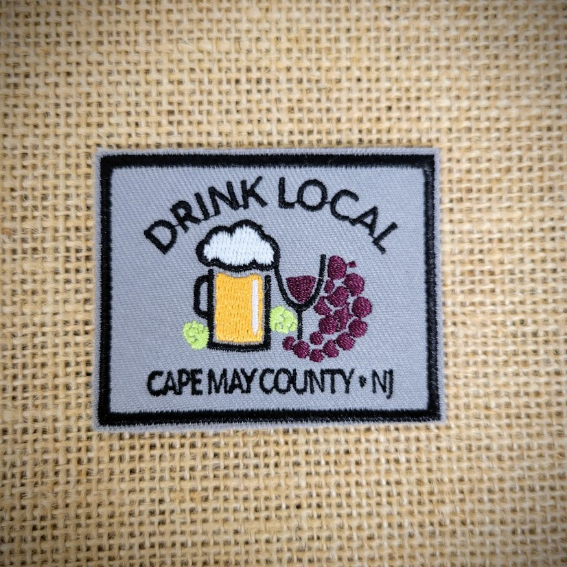 Grey patch with a black frame that features the caption, 'Drink Local' and Cape May County, NJ.