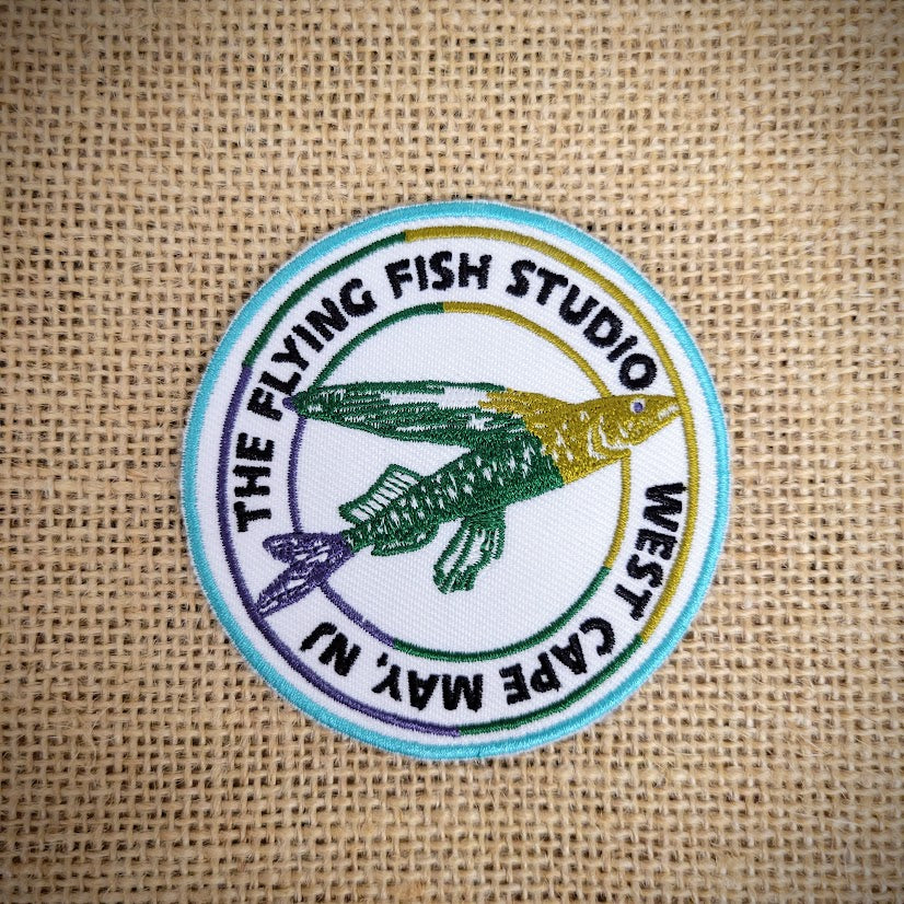 The Flying Fish Studio logo patch that is round and features West Cape May, NJ.