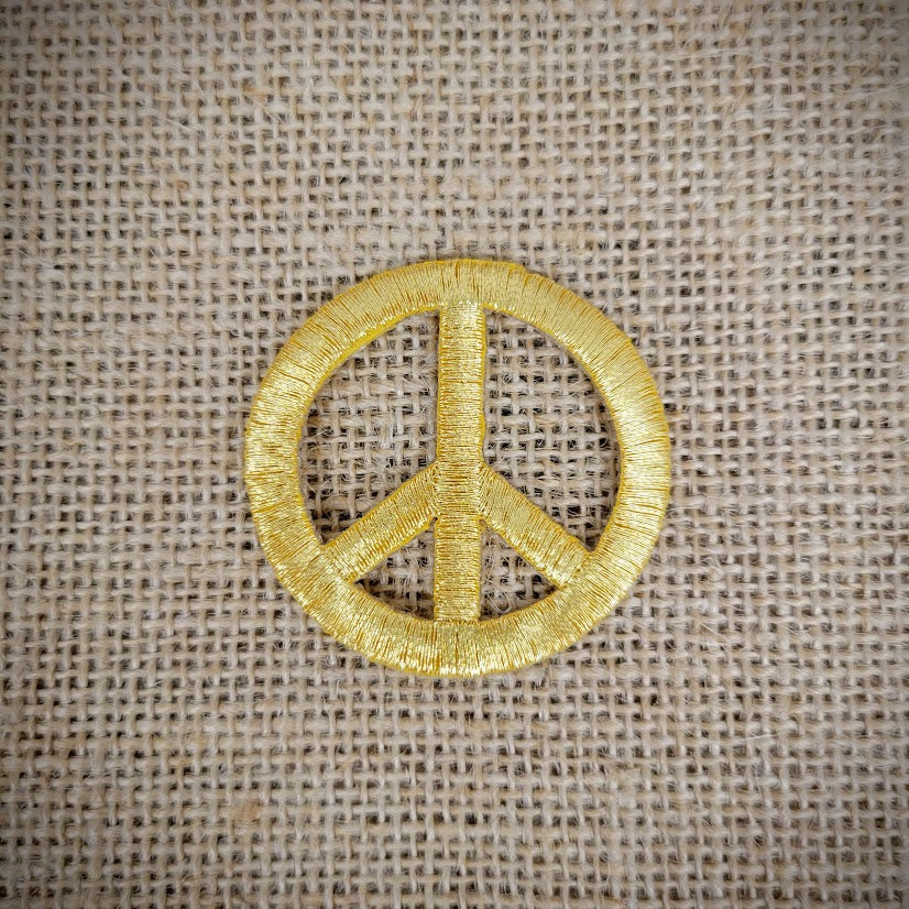 Patch of a gold peace sign.