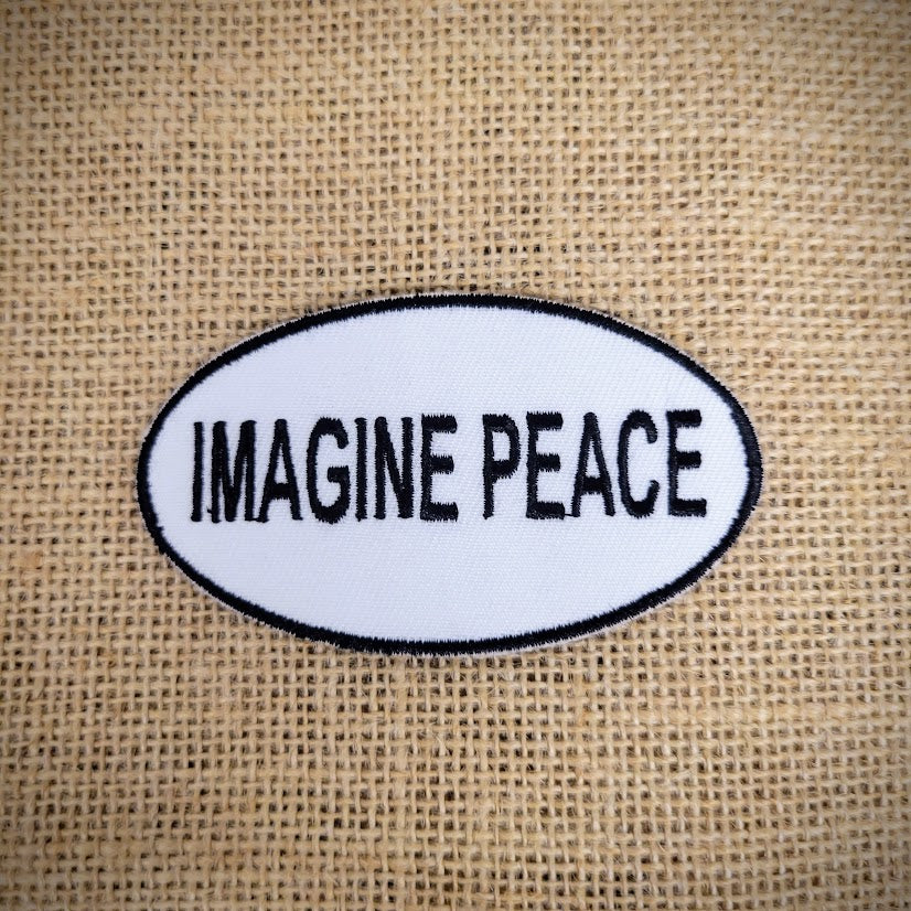 Oval, black-rimmed patch in white that features 'Imagine Peace' in bold text.
