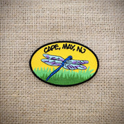 Oval, black-rimmed patch with a dragonfly and Cape May, NJ on the front.