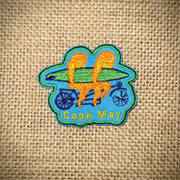 Blue patch with two orange sloths riding a bike while holding a surfboard. Features 'Cape May' on the front.