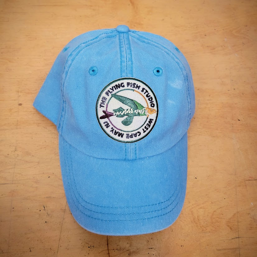 A blue classic hat with a 'Flying Fish Studio' patch on it.
