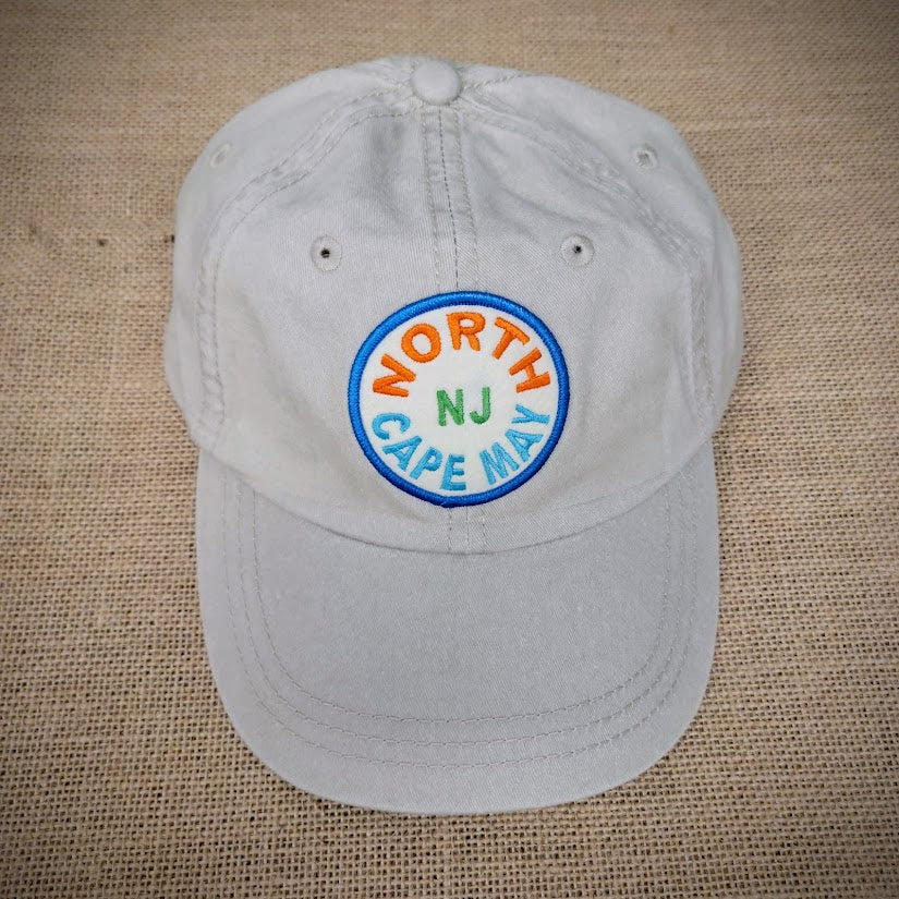 A khaki, classic hat with a 'North Cape May' patch on the front.