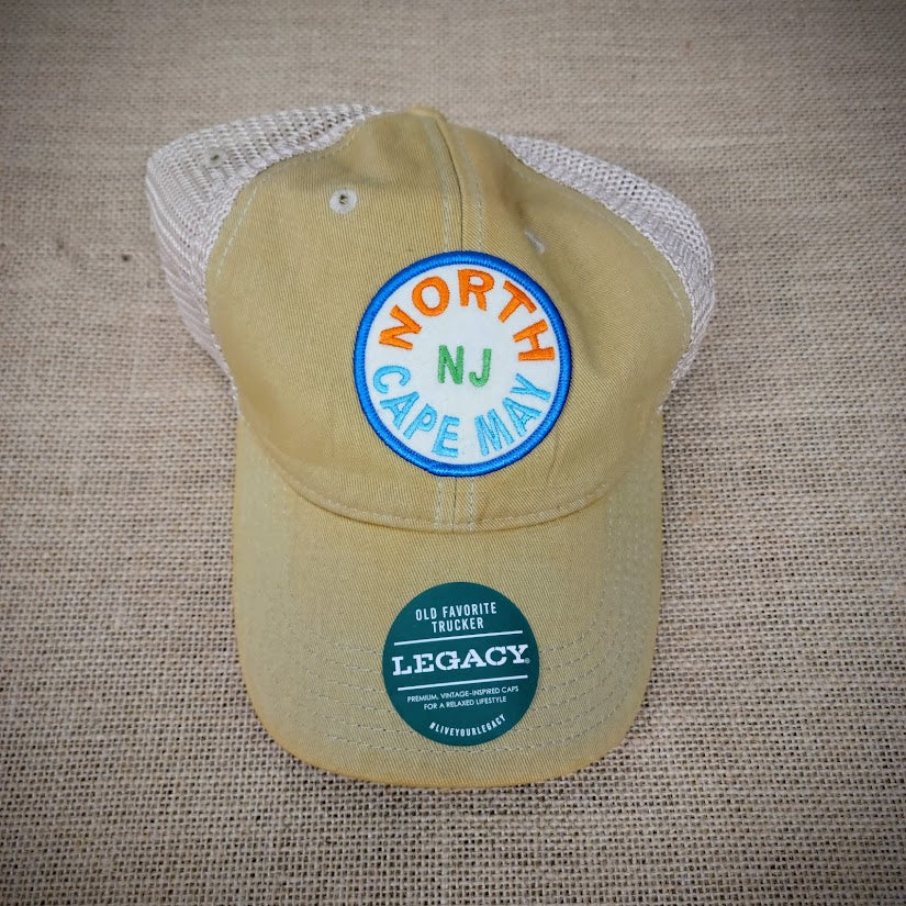 A mustard and khaki trucker hat with a 'North Cape May' patch on it.