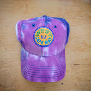 A blue and purple tie-dye hat with a 'West Cape May' patch on it.
