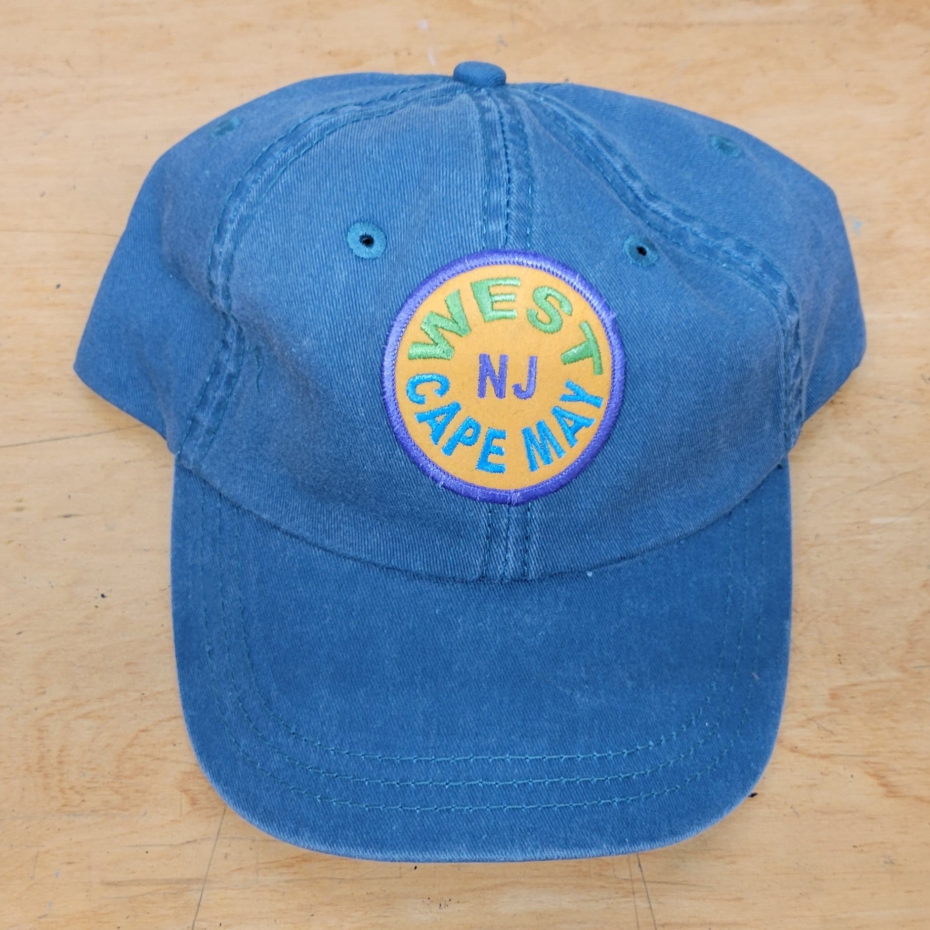 A blue, classic hat with a 'West Cape May' patch on it.