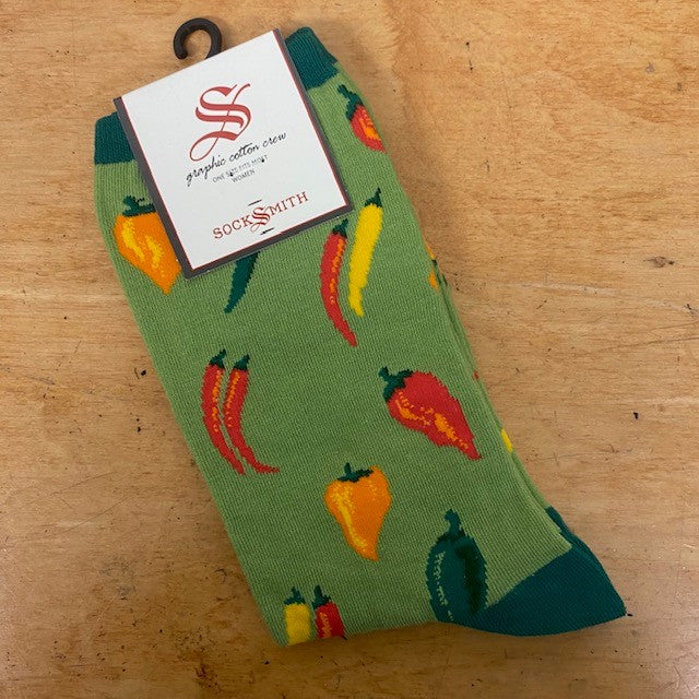 A pair of green socks with chili peppers on them.
