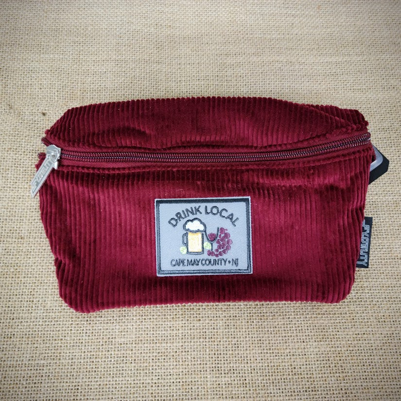 A red fanny pack with a Drink Local patch on it.
