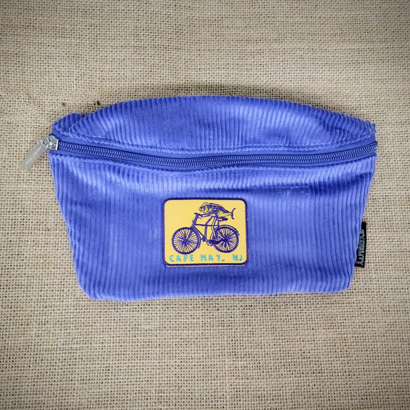 A blue fanny pack with a Fish on a Bike patch on it.