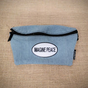 A denim blue fanny pack with an Imagine Peace patch on it.