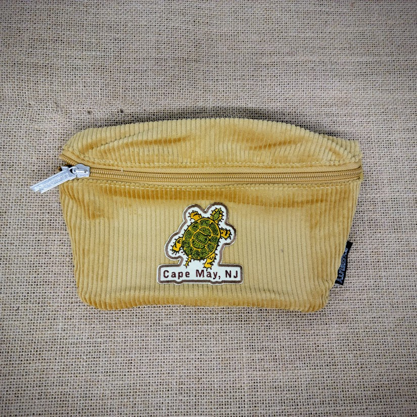 A yellow fanny pack with a Turtle patch on it.