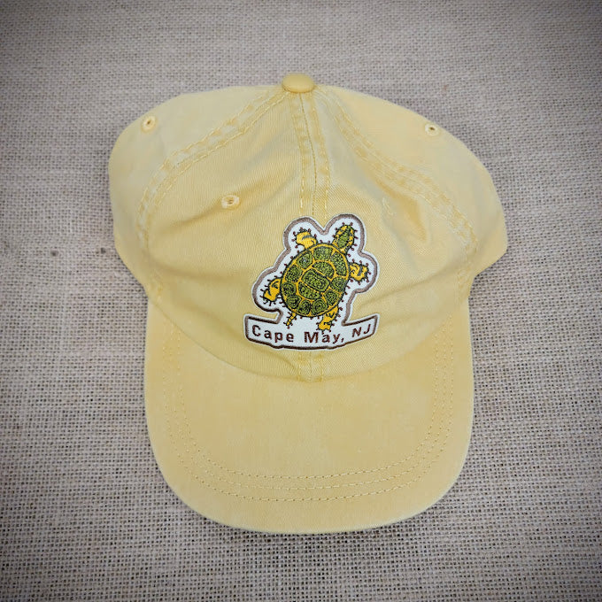 Mustard colored, classic dad hat with a patch of a turtle on the front. Cape May, NJ is captioned underneath it.