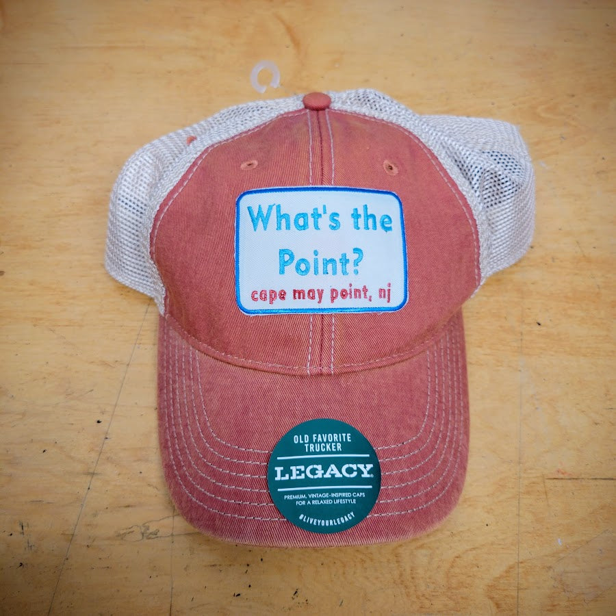 An orange and khaki, trucker hat with a 'What's the Point?' patch on the front.