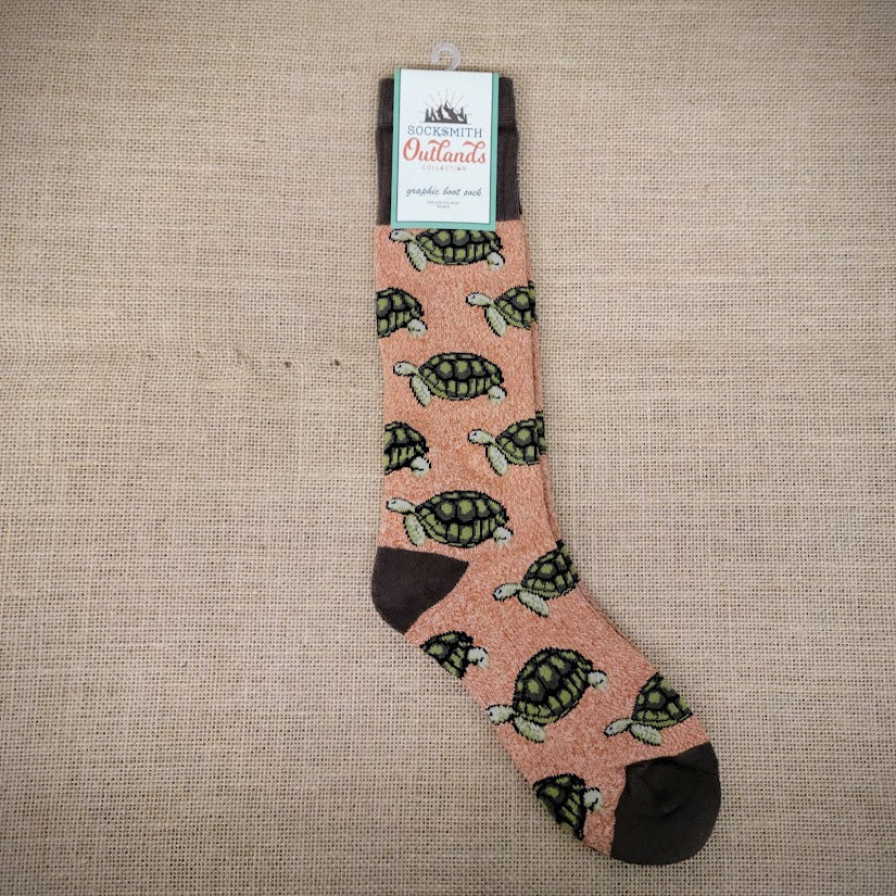 A pair of orange socks with turtles on them.