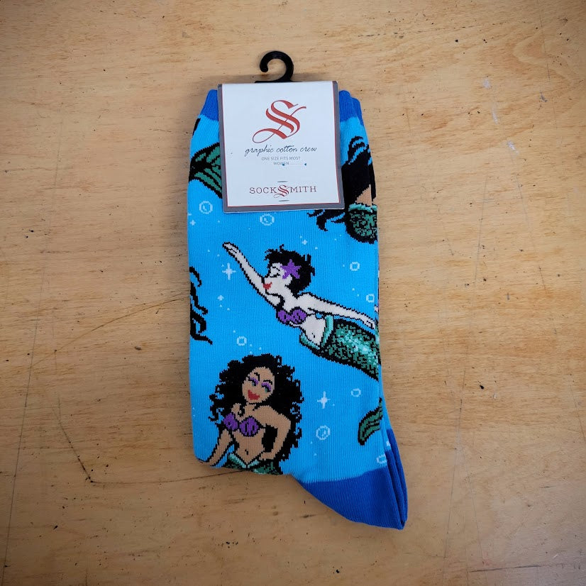A blue pair of socks with mermaids on them.