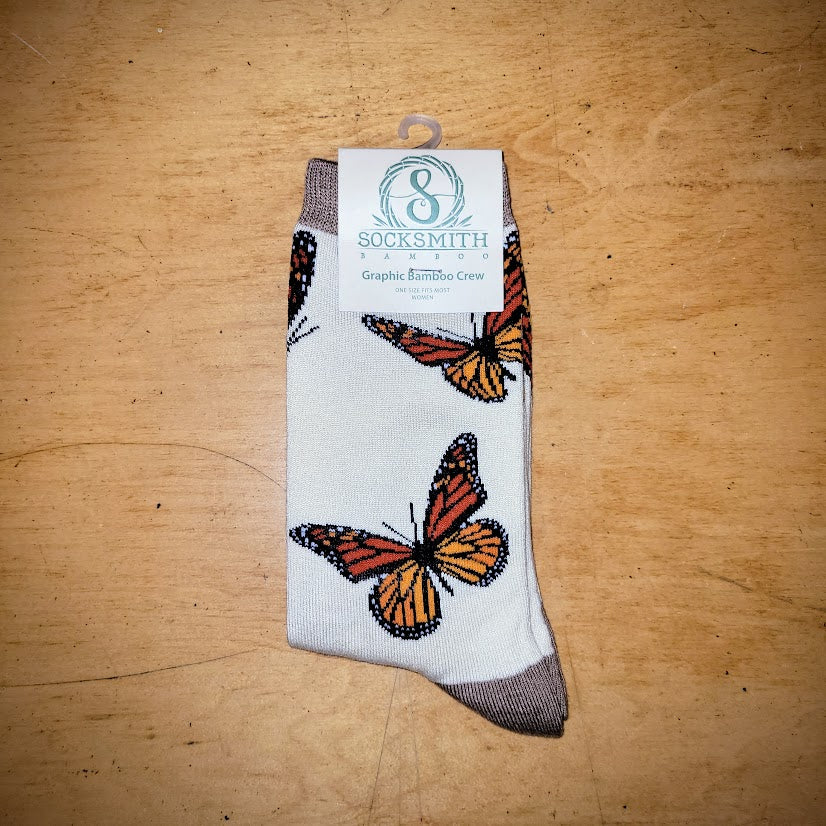 A pair of ivory socks with butterflies on them.