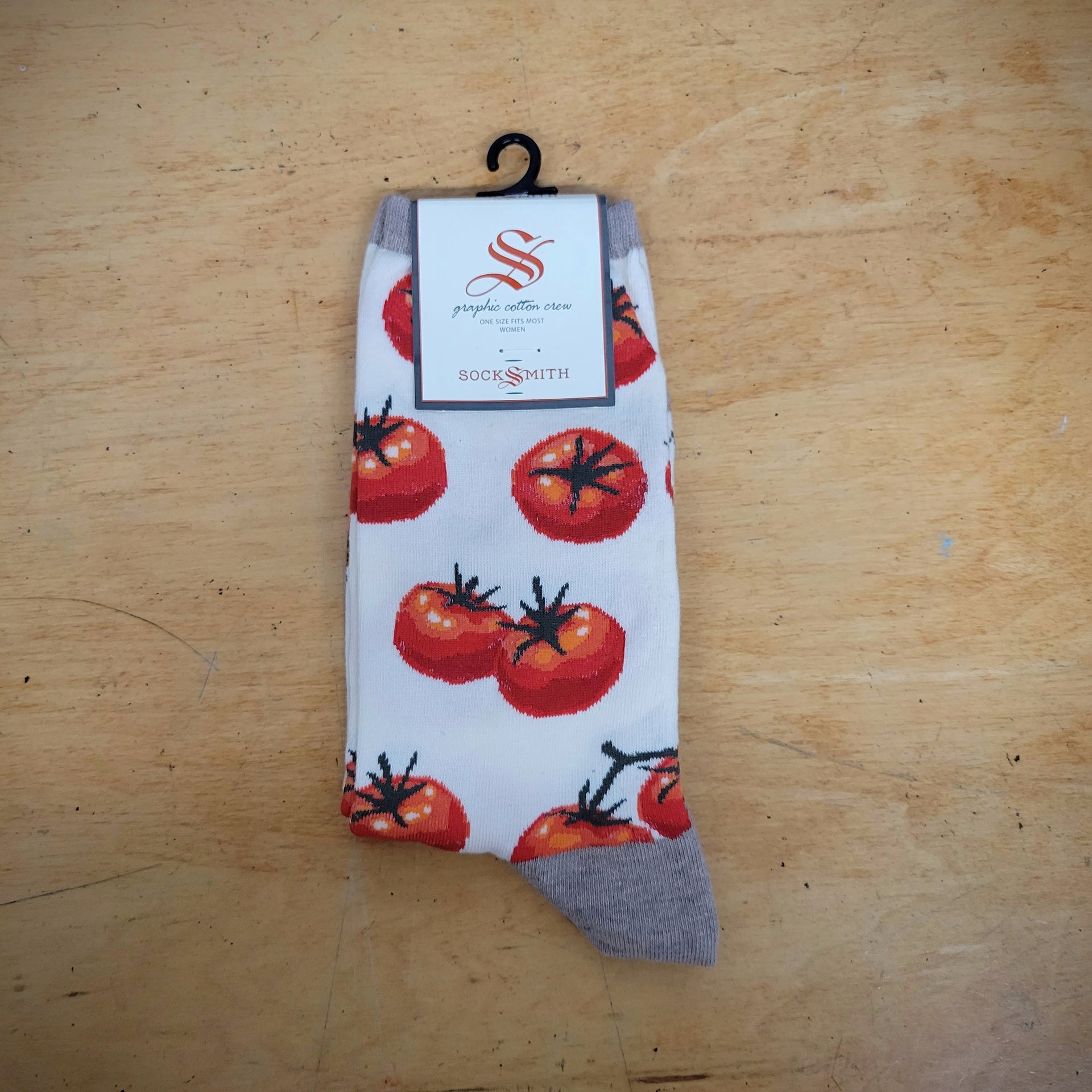 An ivory pair of socks with tomatoes on them.