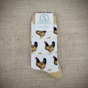 An ivory and mustard pair of socks with hens and eggs on it.