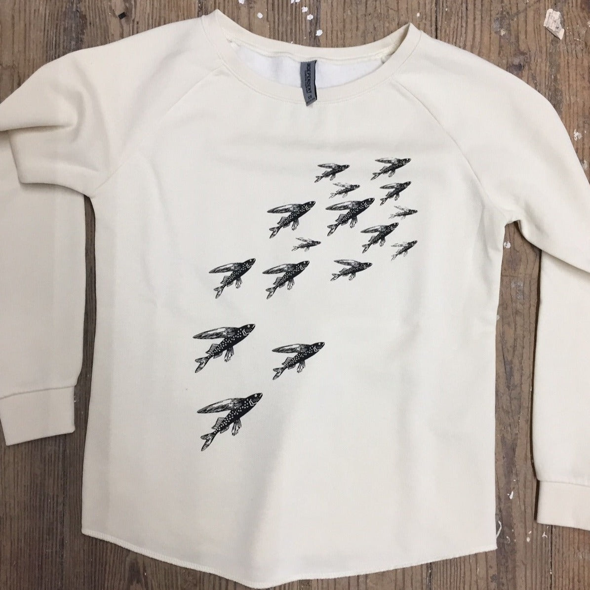 Cream colored sweatshirt featuring the 'School of Fish' design on the front chest in black ink.