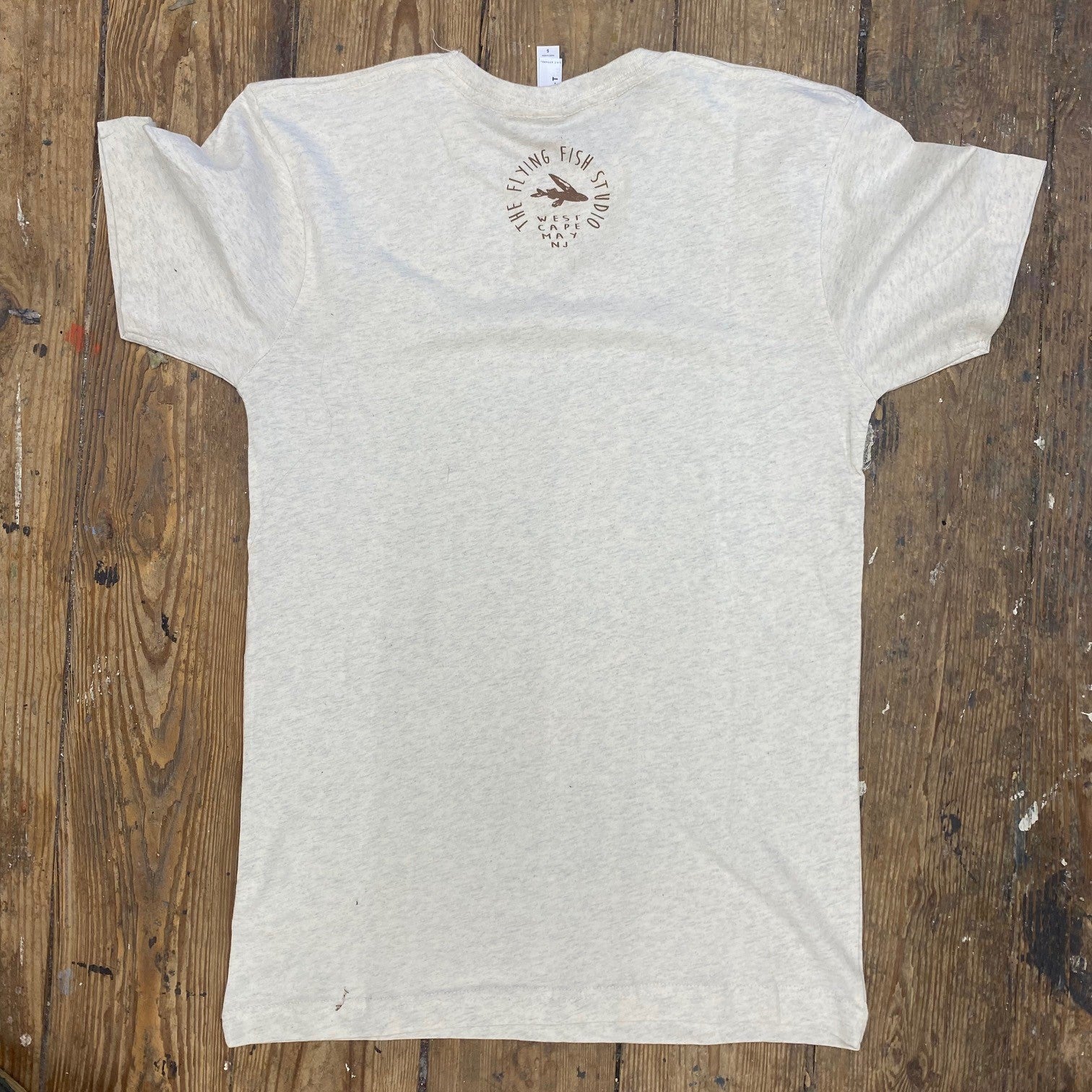 A heather, greyish-cream t-shirt with the 'Flying Fish Studio' design on the back neck in brown ink.