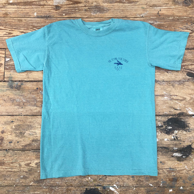 A blue t-shirt with the "Flying Fish Studio' captioned on the left chest  in blue ink.